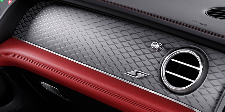 Bentley Copenhagen Bentley Bentayga S SUV front interior dash with Dark Tint Diamond Brushed Aluminium veneer and S badge surrounded by Hotspur red and Beluga black hide