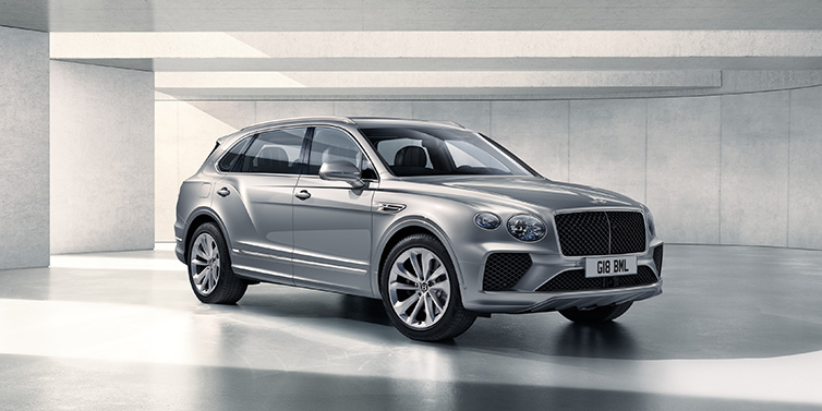 Bentley Copenhagen Bentley Bentayga Extended Wheelbase SUV front three quarter in Moonbeam paint with a grey background